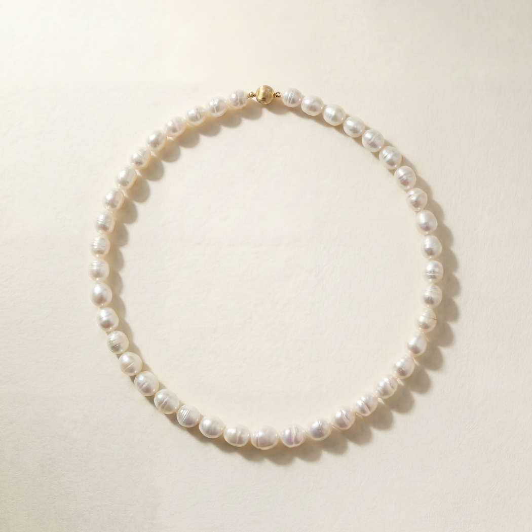 Pearl necklace on a light beige background