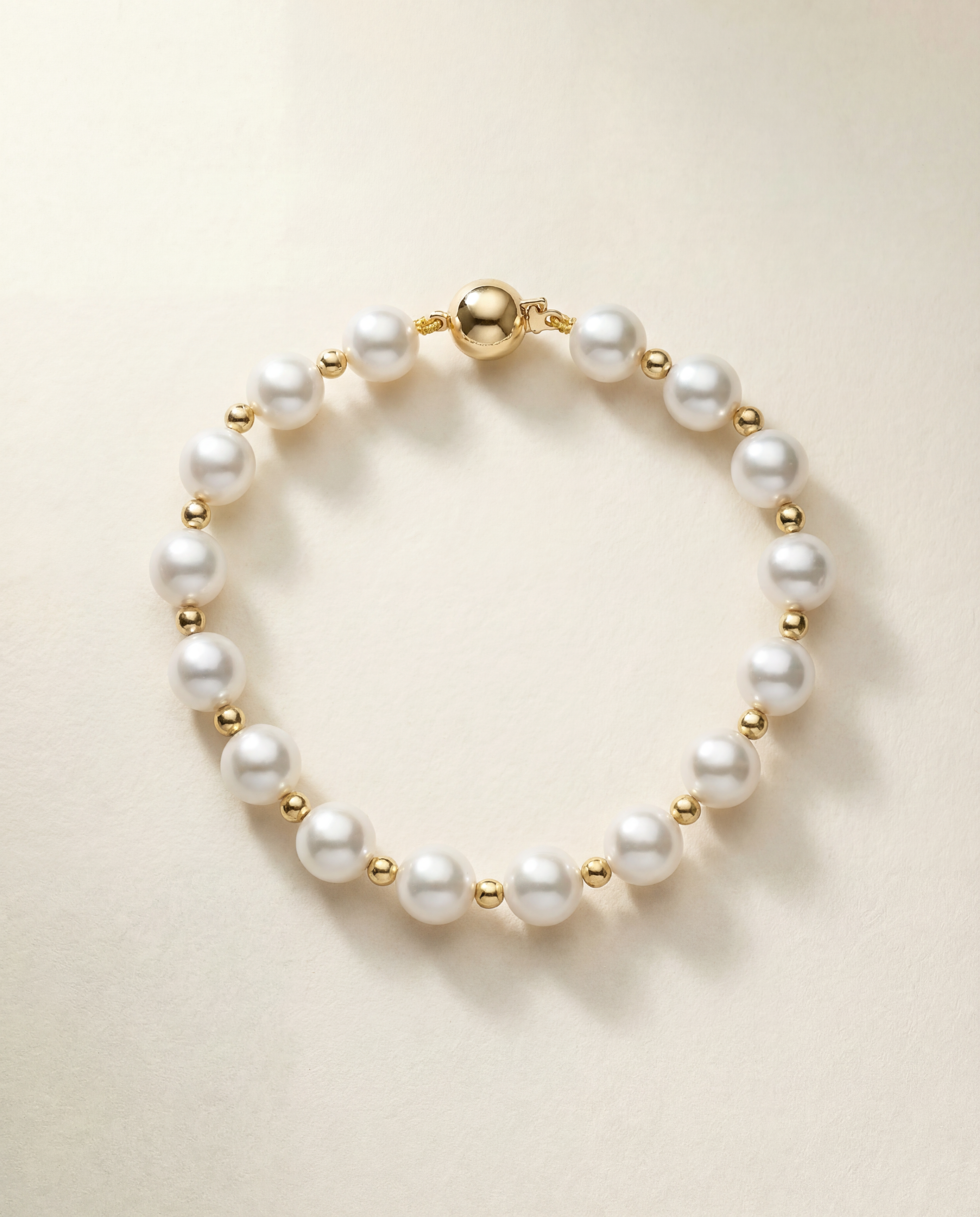 Pearl bracelet with gold filled beads on a beige background