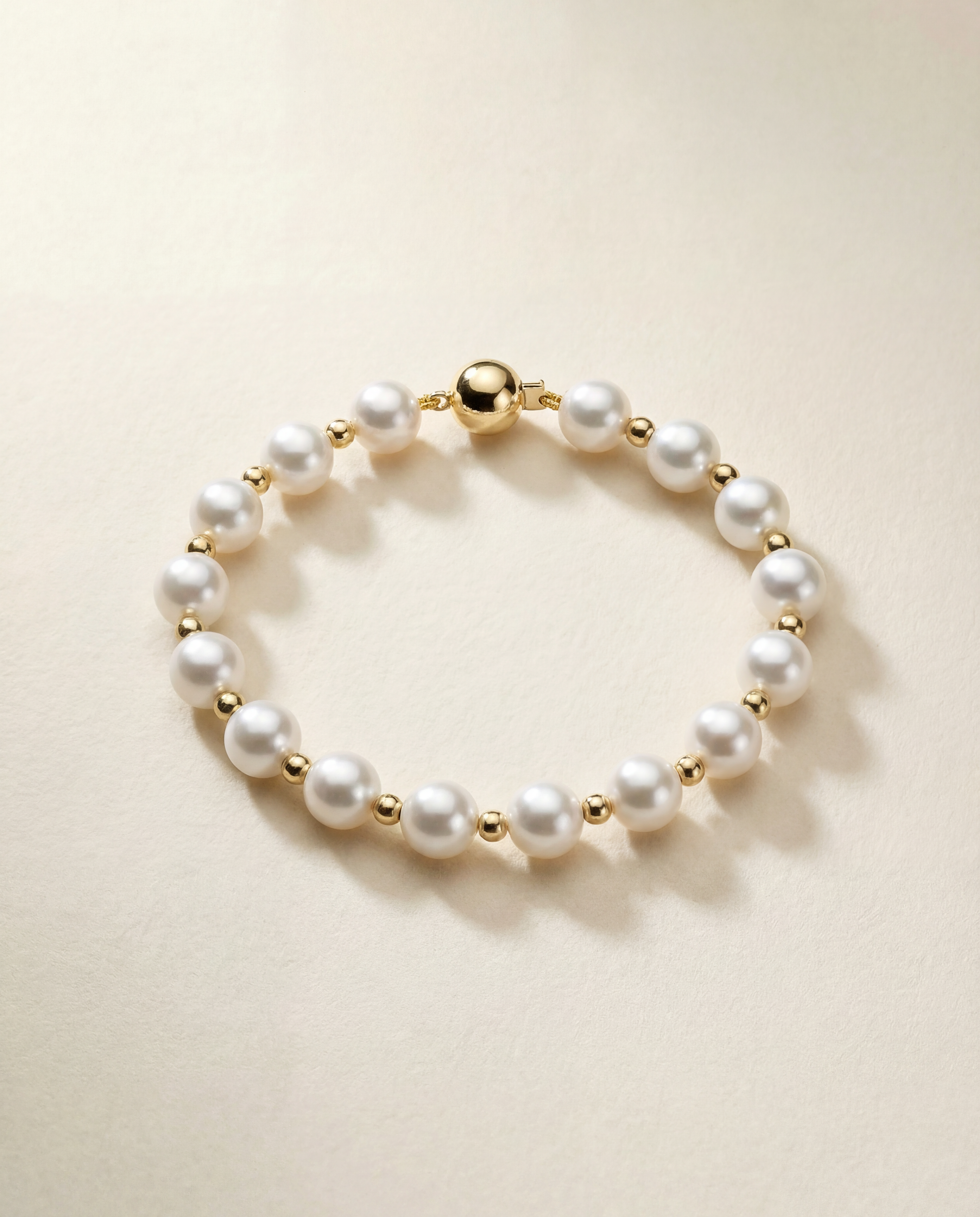 Pearl bracelet with gold filled beads on a beige background