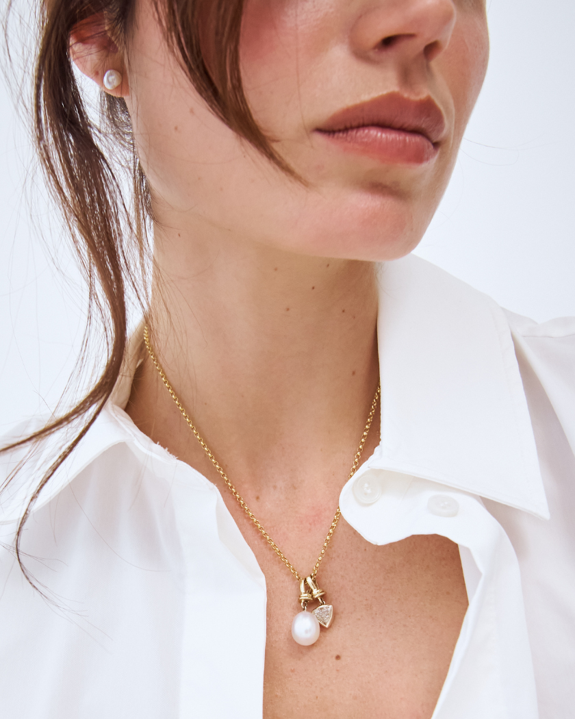 Model wearing a 9k yellow gold belcher chain with a south sea pearl and trilliant champagne diamond charm