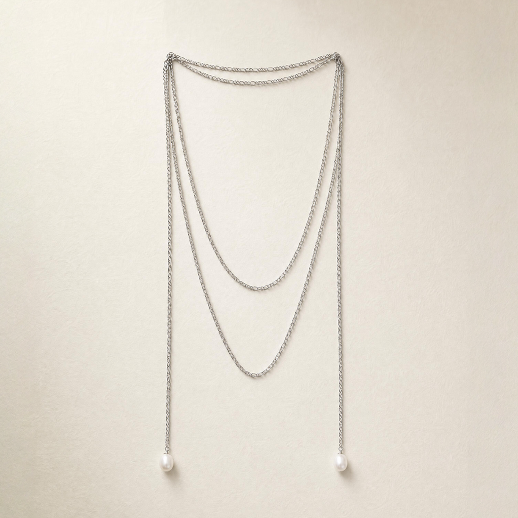 A silver multi-layer chain necklace with south sea pearls, displayed against a light beige background.