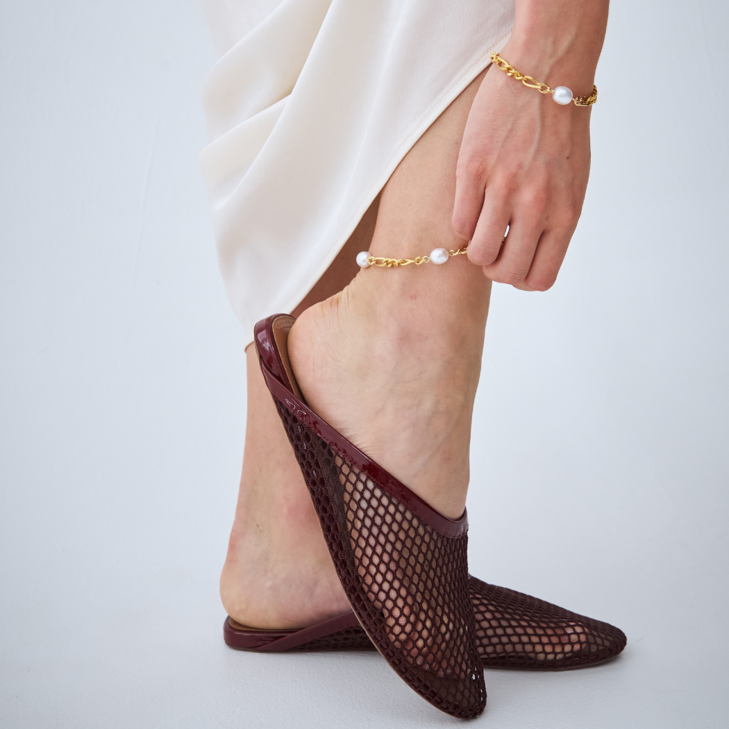 Yellow Gold Figaro chain anklet and bracelet with south sea pearl on model.