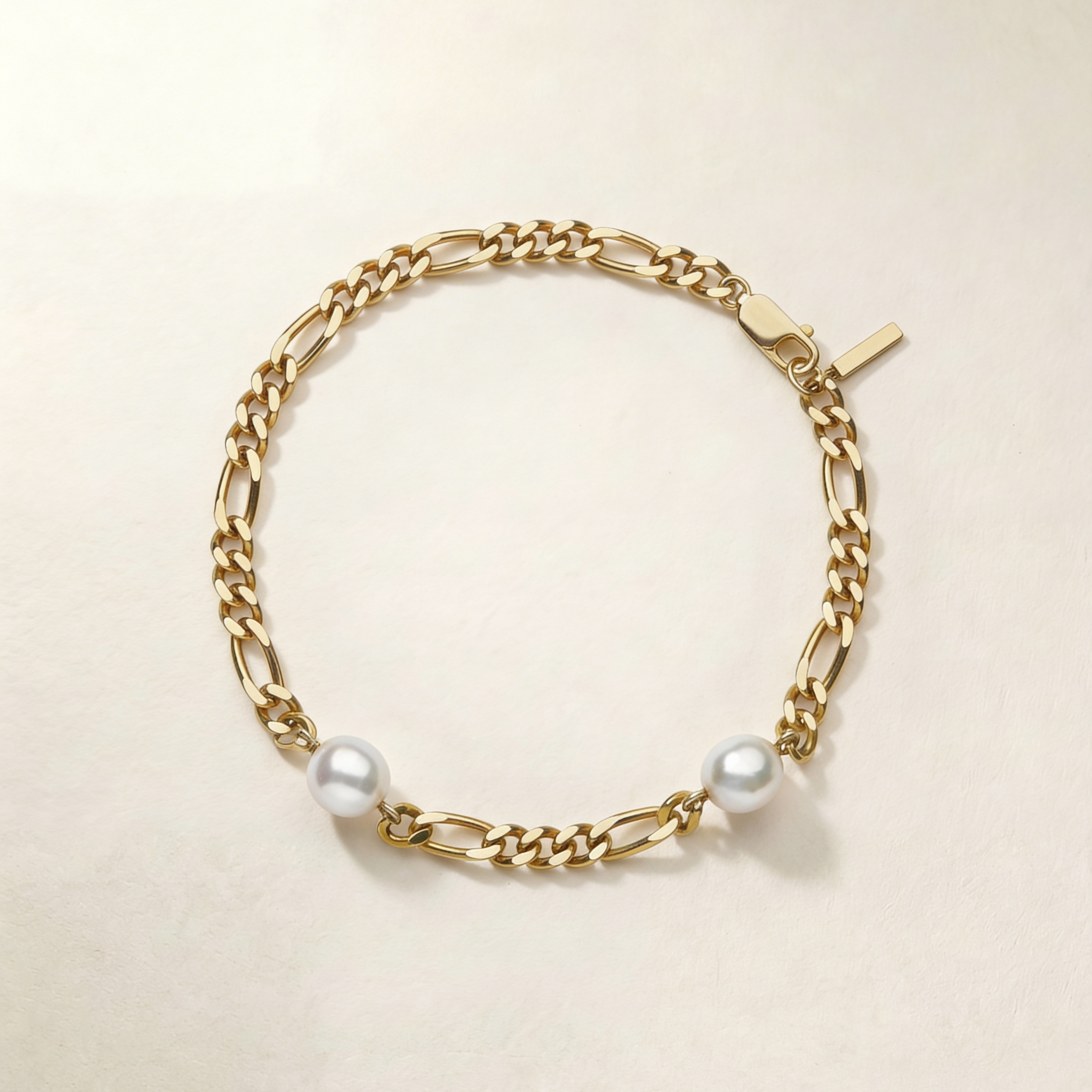 Gold chain anklet with pearls on a beige background