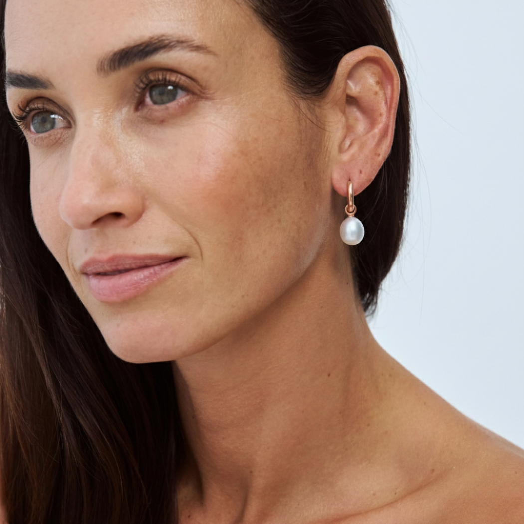 Close-up of a model wearing a South Sea pearl drop earring on a 9k solid gold hoop.