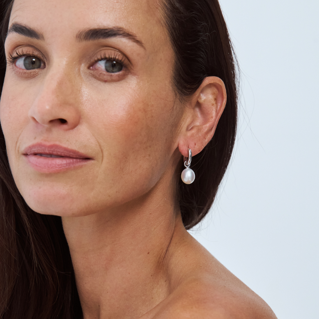 Close-up of a model wearing a South Sea pearl drop earring on a 9k solid gold hoop.