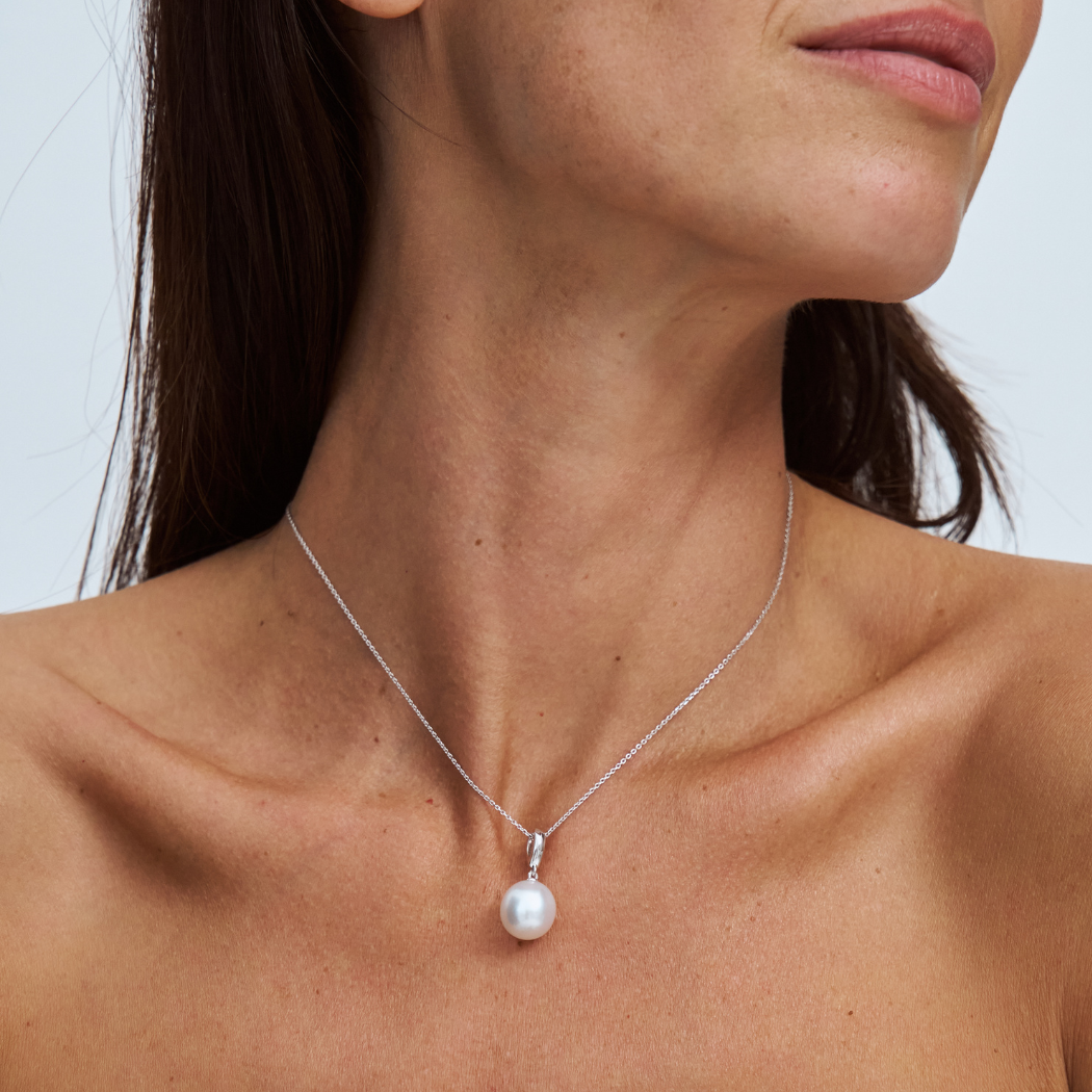 south sea pearl on a fine 9k solid gold chain with a removable pendant on a model with a plain background