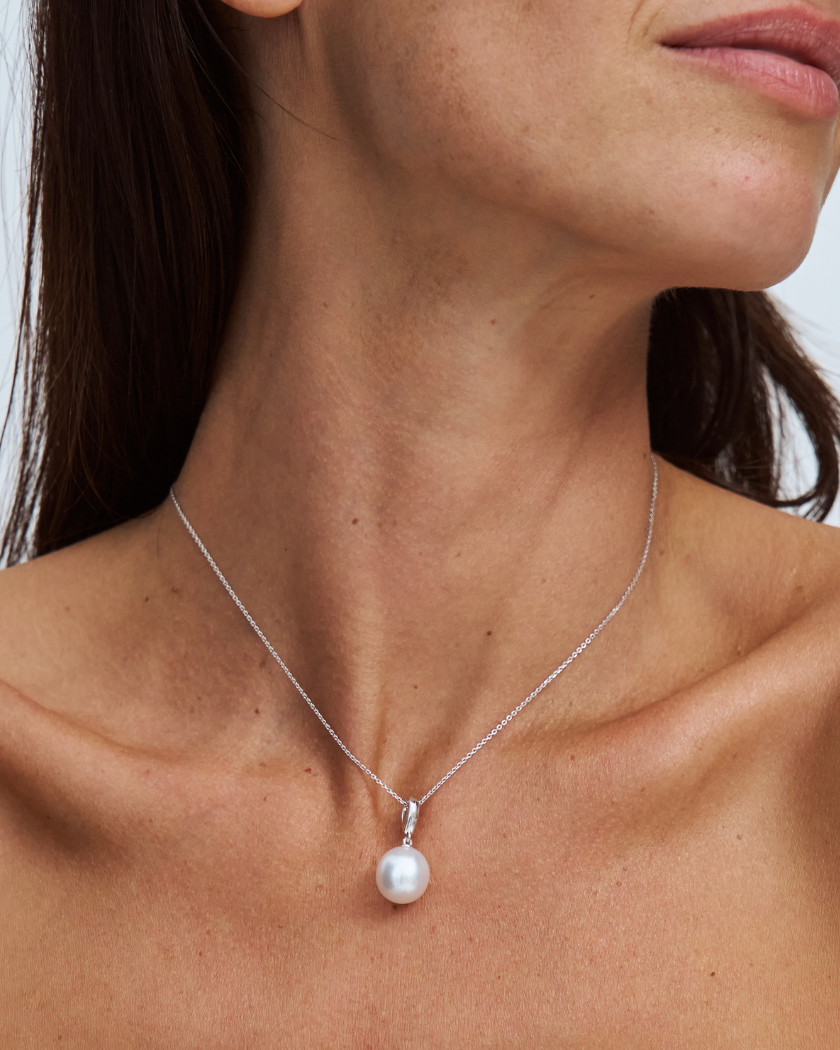 south sea pearl on a fine 9k solid gold chain with a removable pendant on a model with a plain background