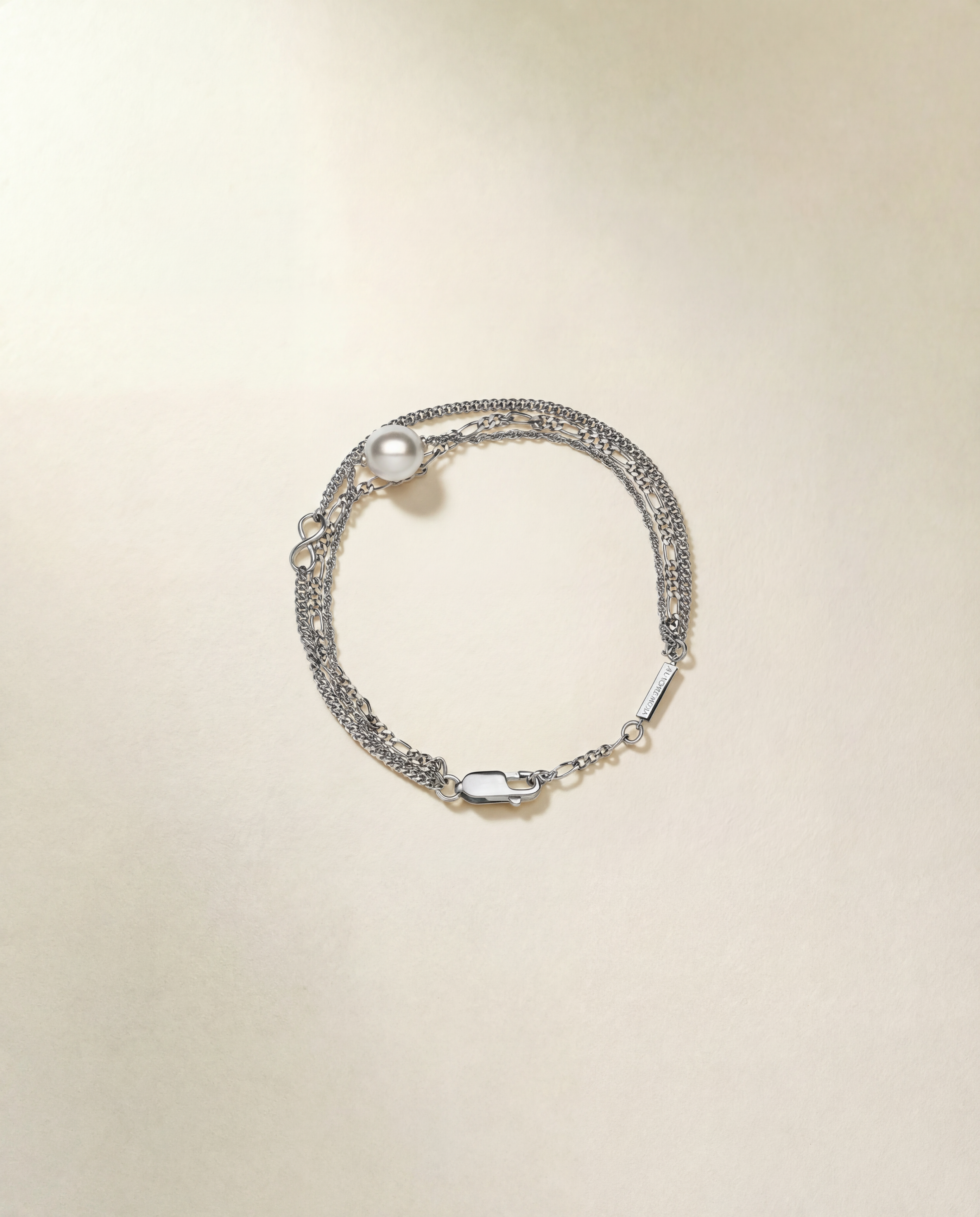 Silver bracelet with pearls on a beige background