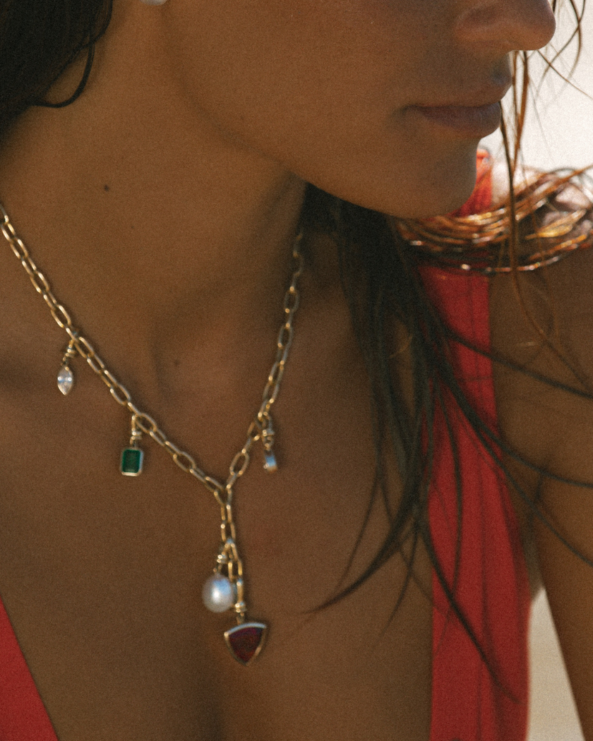 Close-up of 9k solid gold Italian chain necklace with gemstones and South Sea pearl charms.