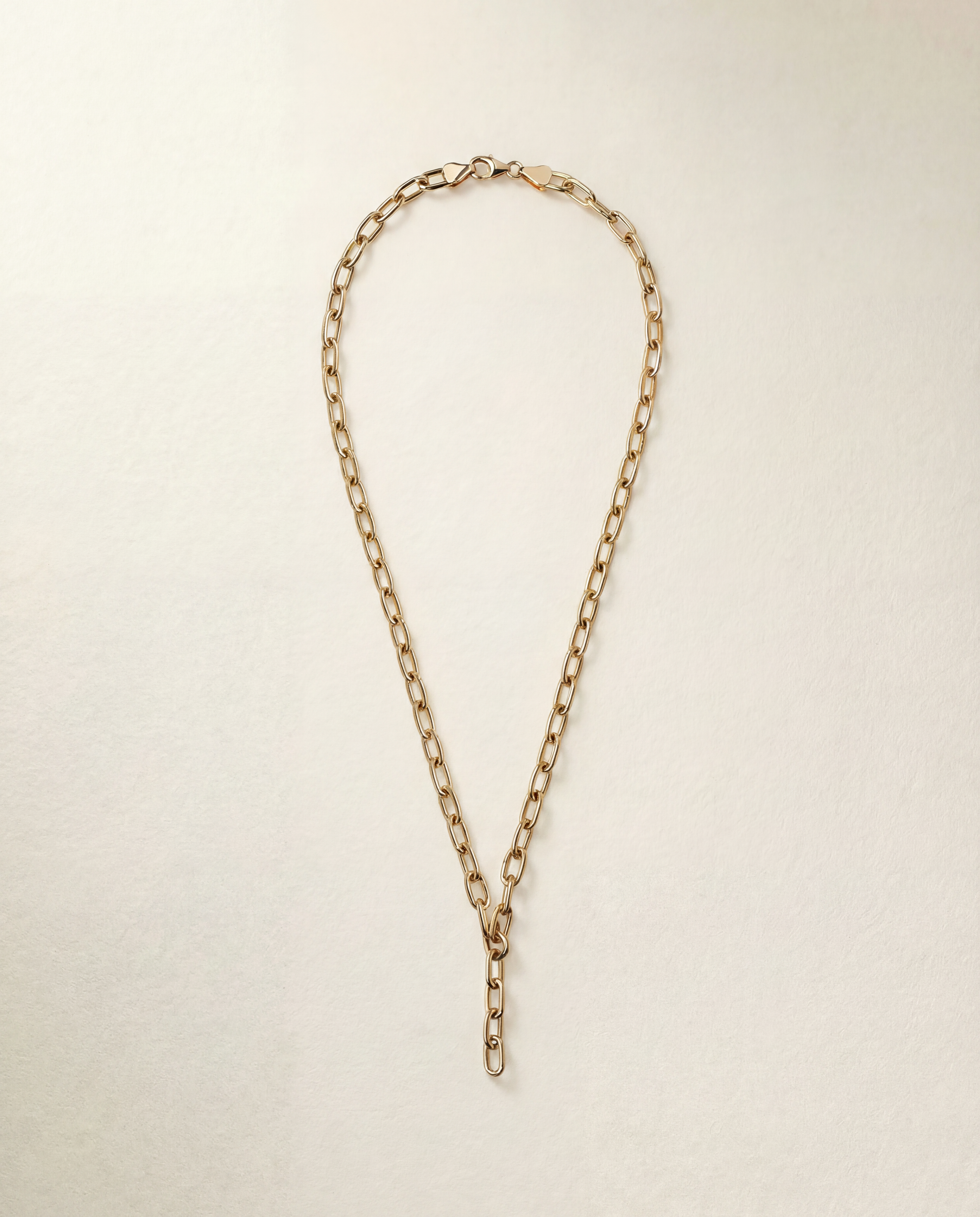 Gold chain necklace on a light beige background