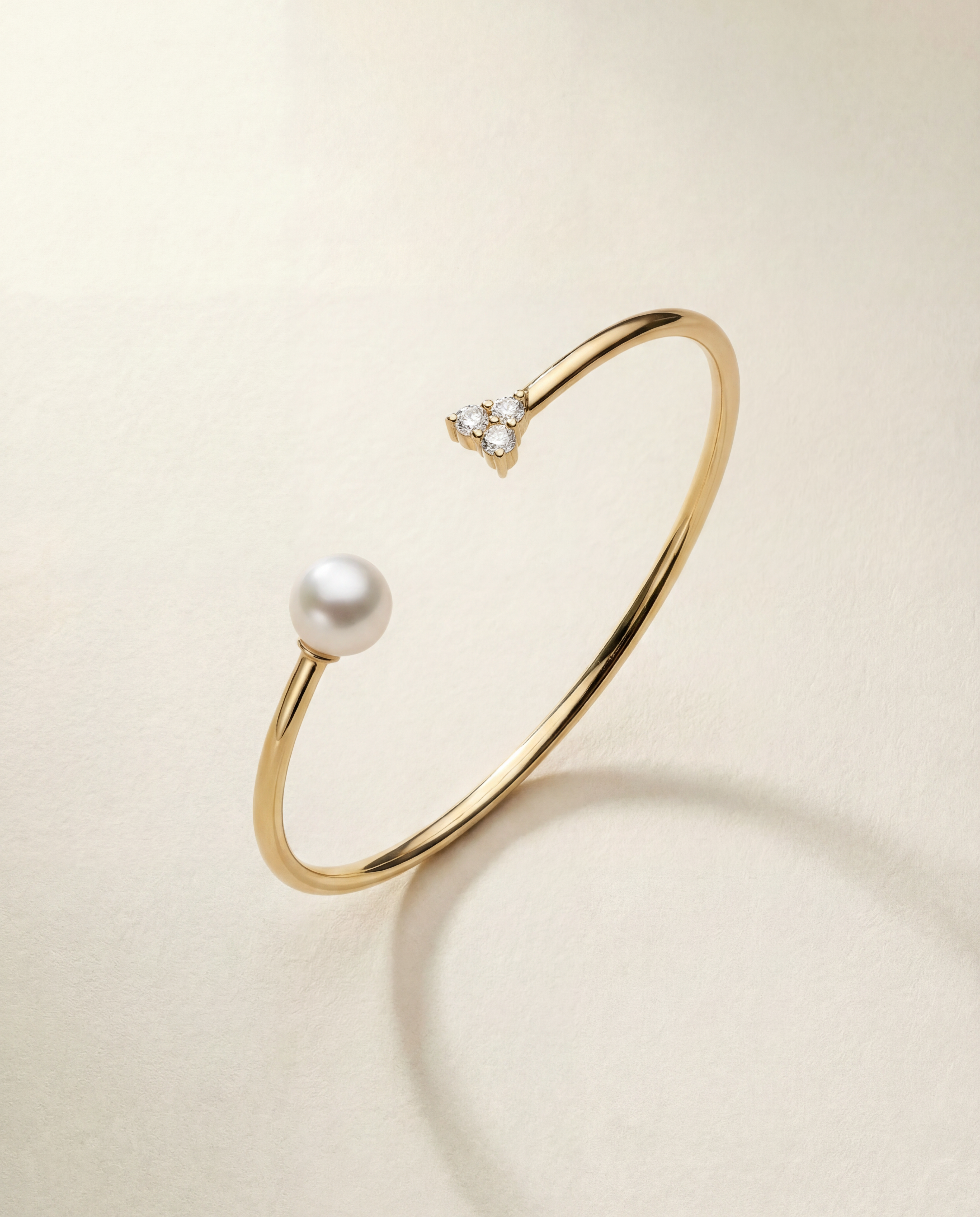 Gold bracelet with a pearl and small sapphires on a beige background