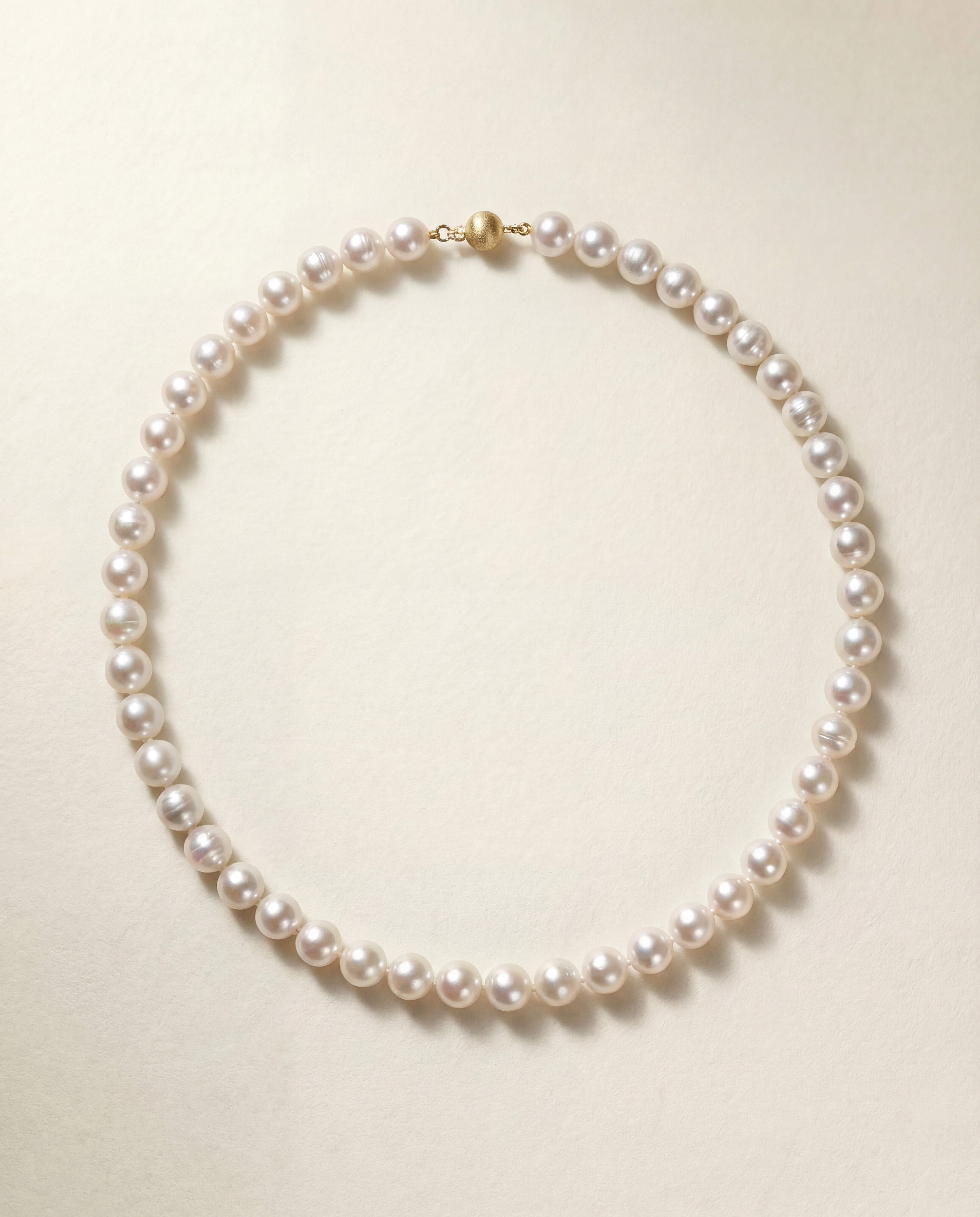 Pearl necklace on a light beige background