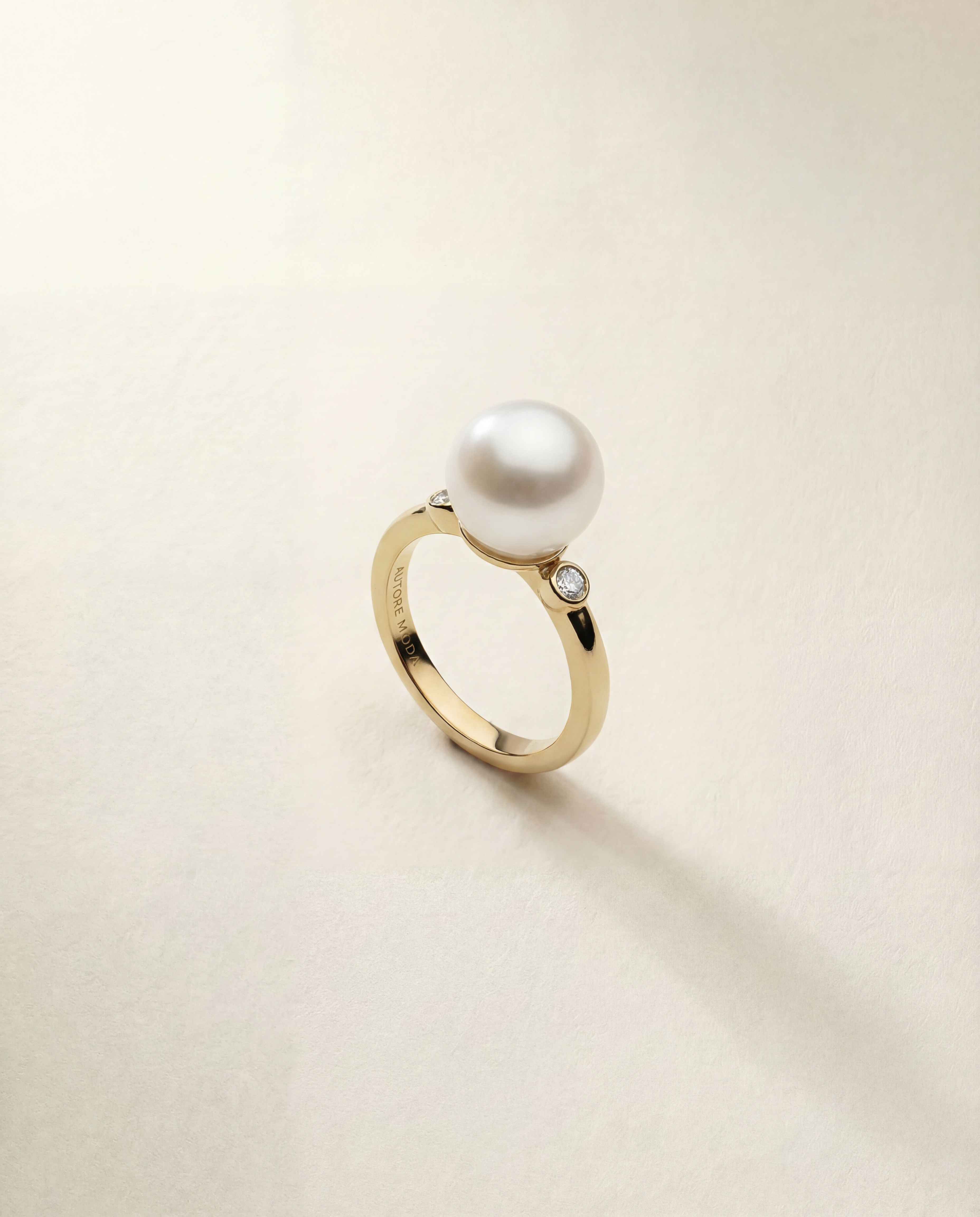 Gold ring with a pearl on a light beige background