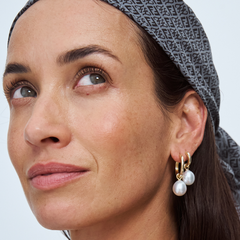 Woman wearing south sea pearl earrings with a neutral background