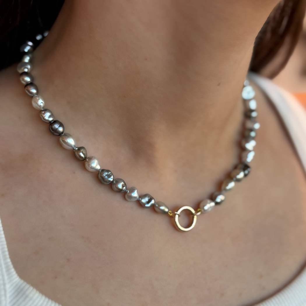 Tahitian keshi pearl necklace with a 9ct yellow gold circular clasp shown on a model.