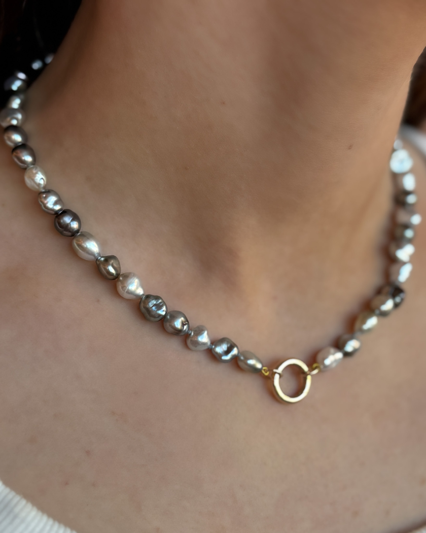 Tahitian keshi pearl necklace with a 9ct yellow gold circular clasp shown on a model.