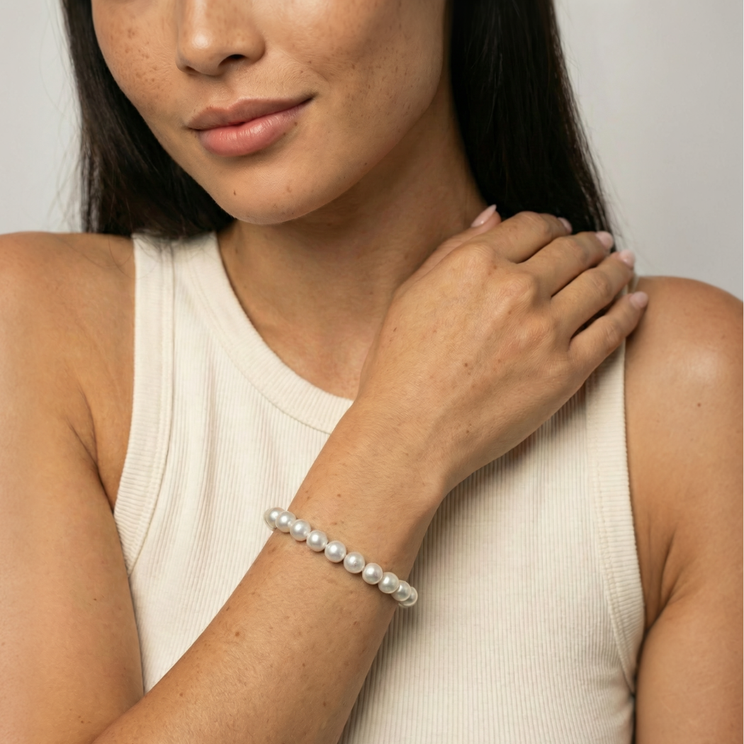 Woman wearing a south sea pearl bracelet on a plain background