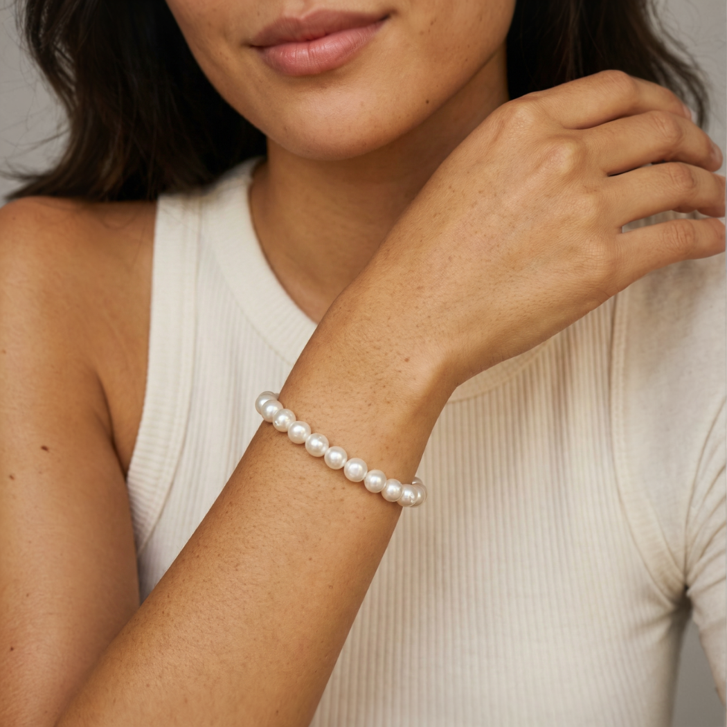 Woman wearing a south sea pearl bracelet on a neutral background
