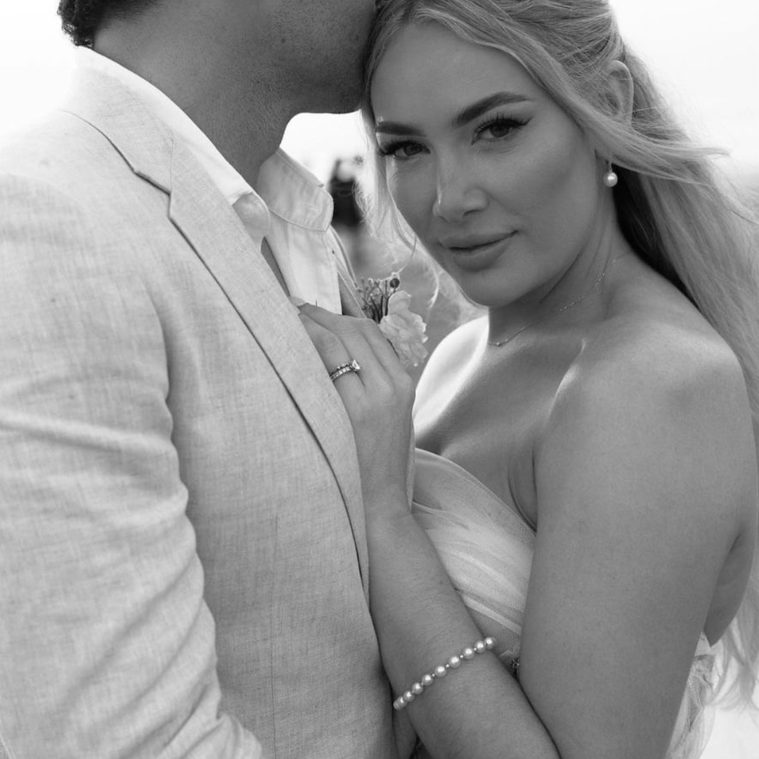 Bride wearing an AUTORE MODA pearl bracelet and earring, embracing her groom