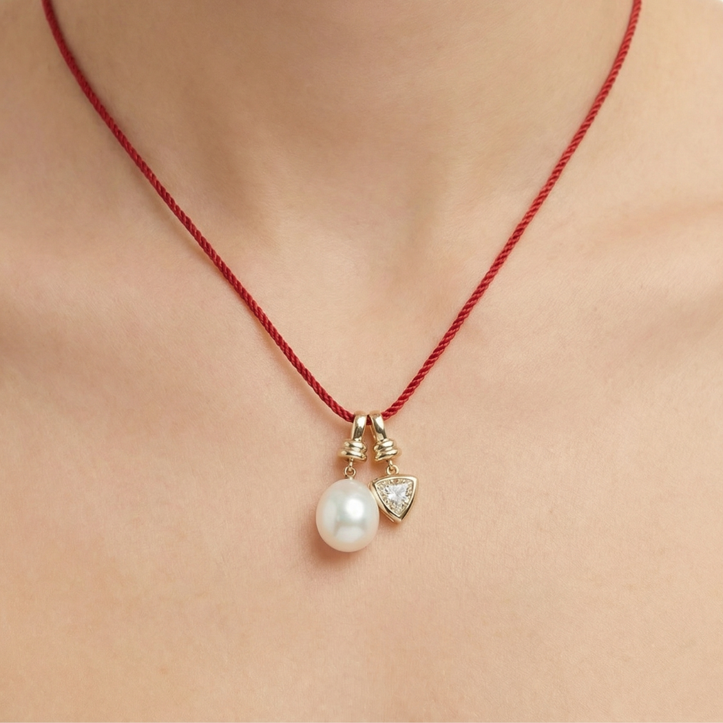 Necklace with a pearl pendant and red string on a person's neck