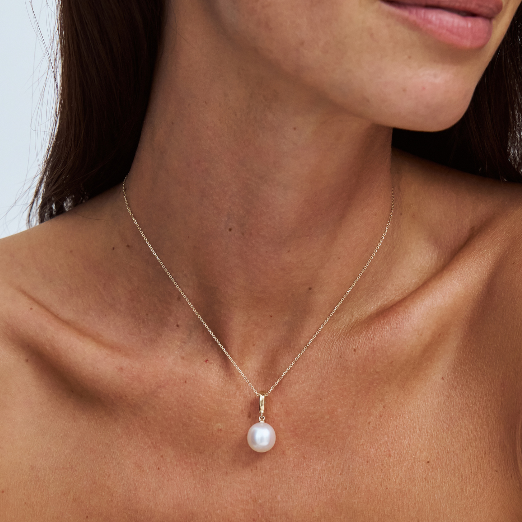 south sea pearl on a fine 9k solid gold chain with a removable pendant on a model with a plain background 