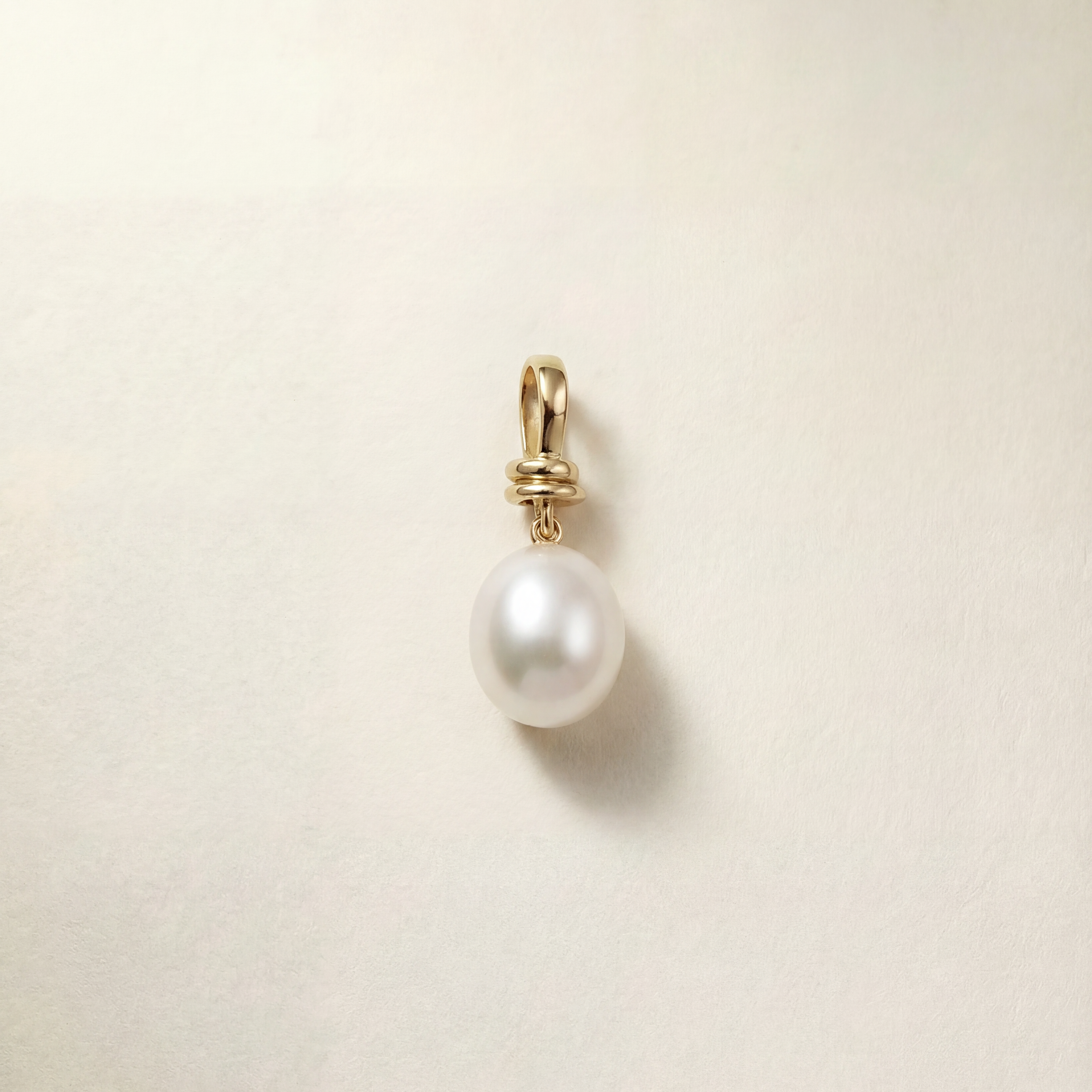 Pearl pendant against a beige background