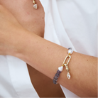 Close-up of a model wearing an iolite and keshi bracelet with a champagne Marquise diamond