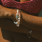 Layered close-up of multiple South Sea keshi pearl and gemstone bracelets with 9k solid gold hinged clasp made for layering and charms.