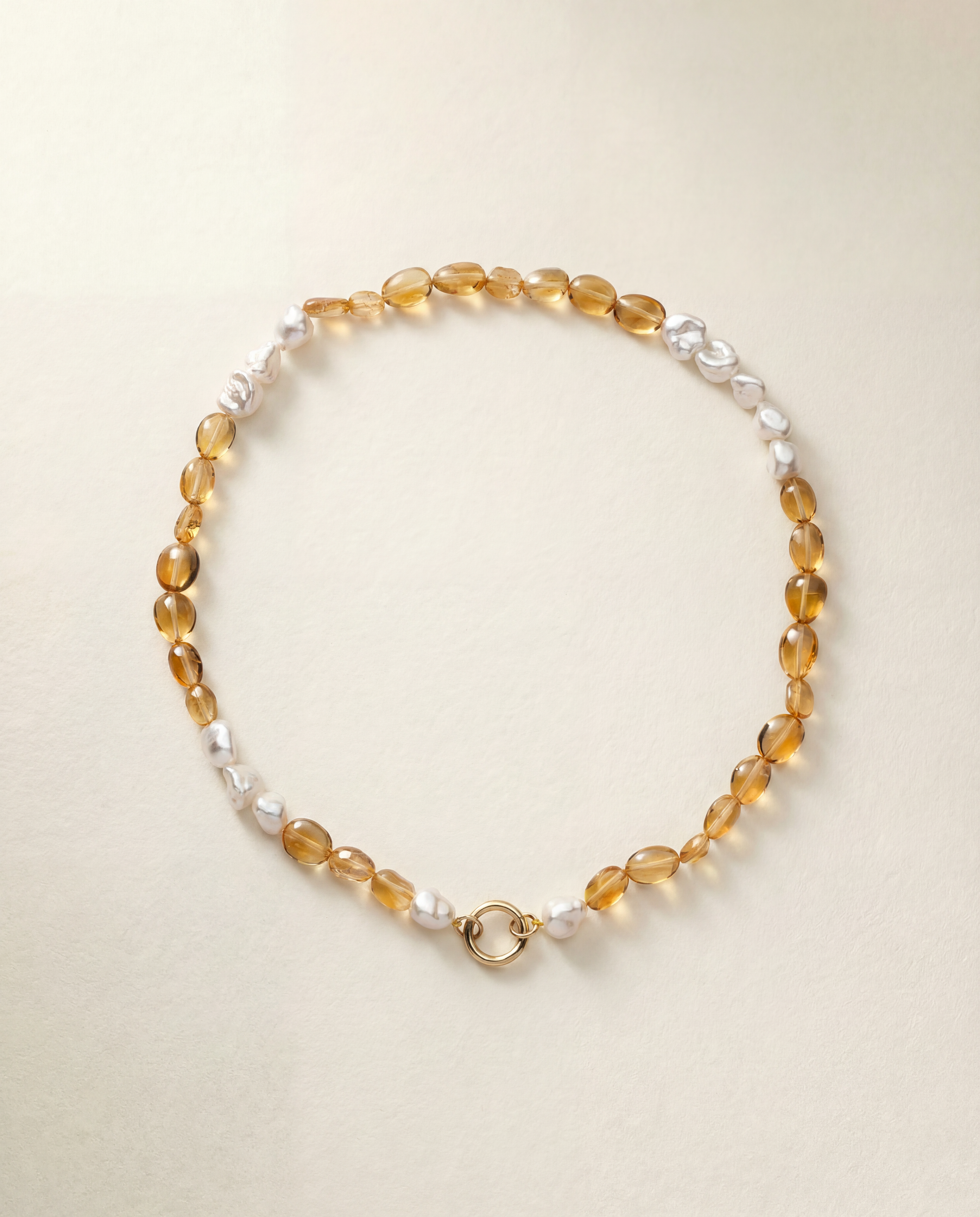 Beaded necklace with yellow beads and pearls on a beige background