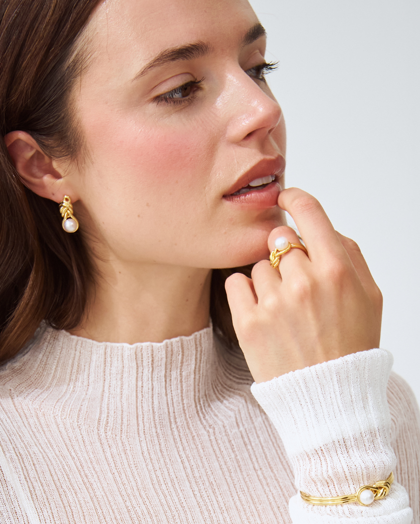 Woman wearing melanie south sea pearl earrings, ring, and bracelet in 18k yellow gold vermeil.