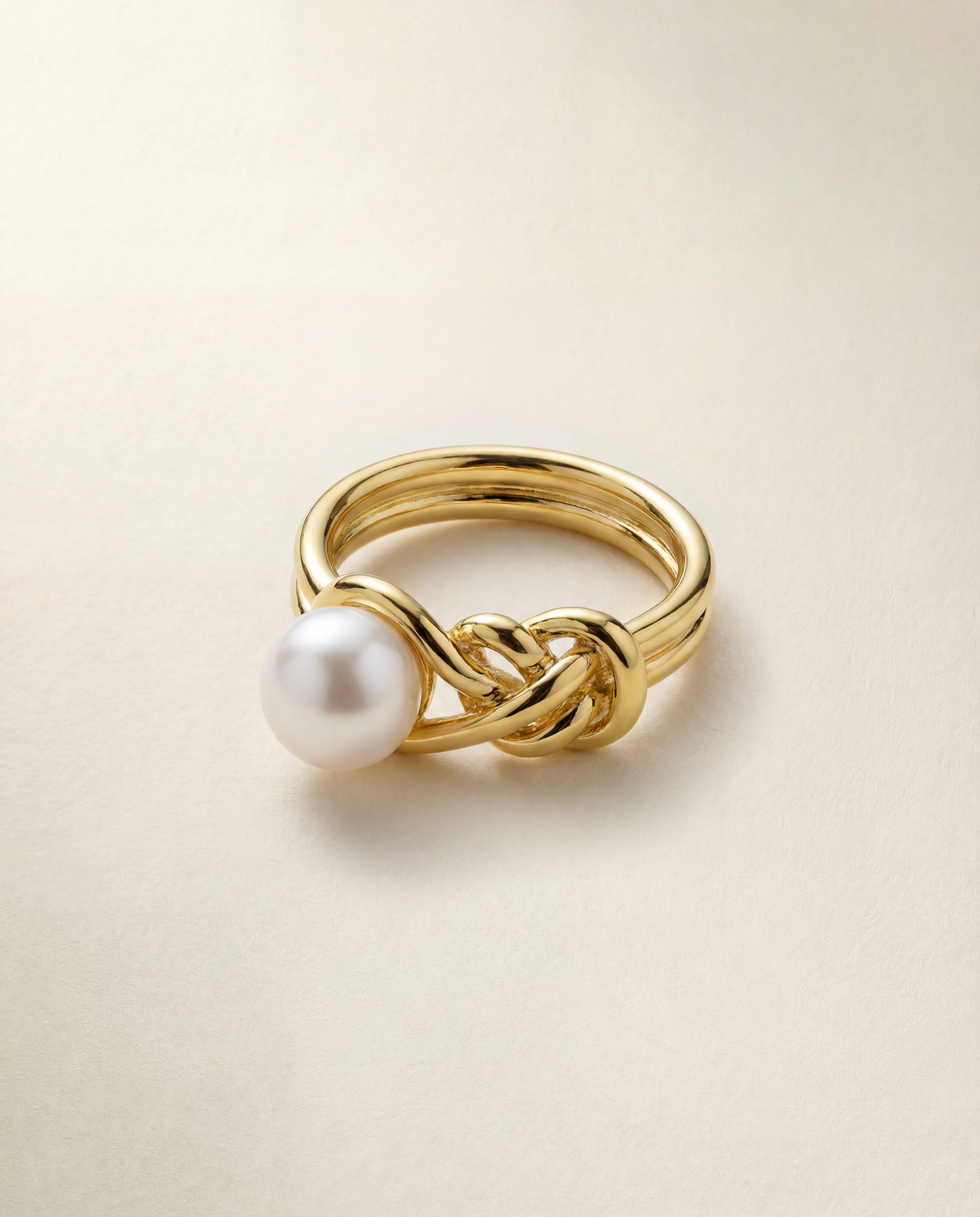 Gold ring with a pearl on a beige background