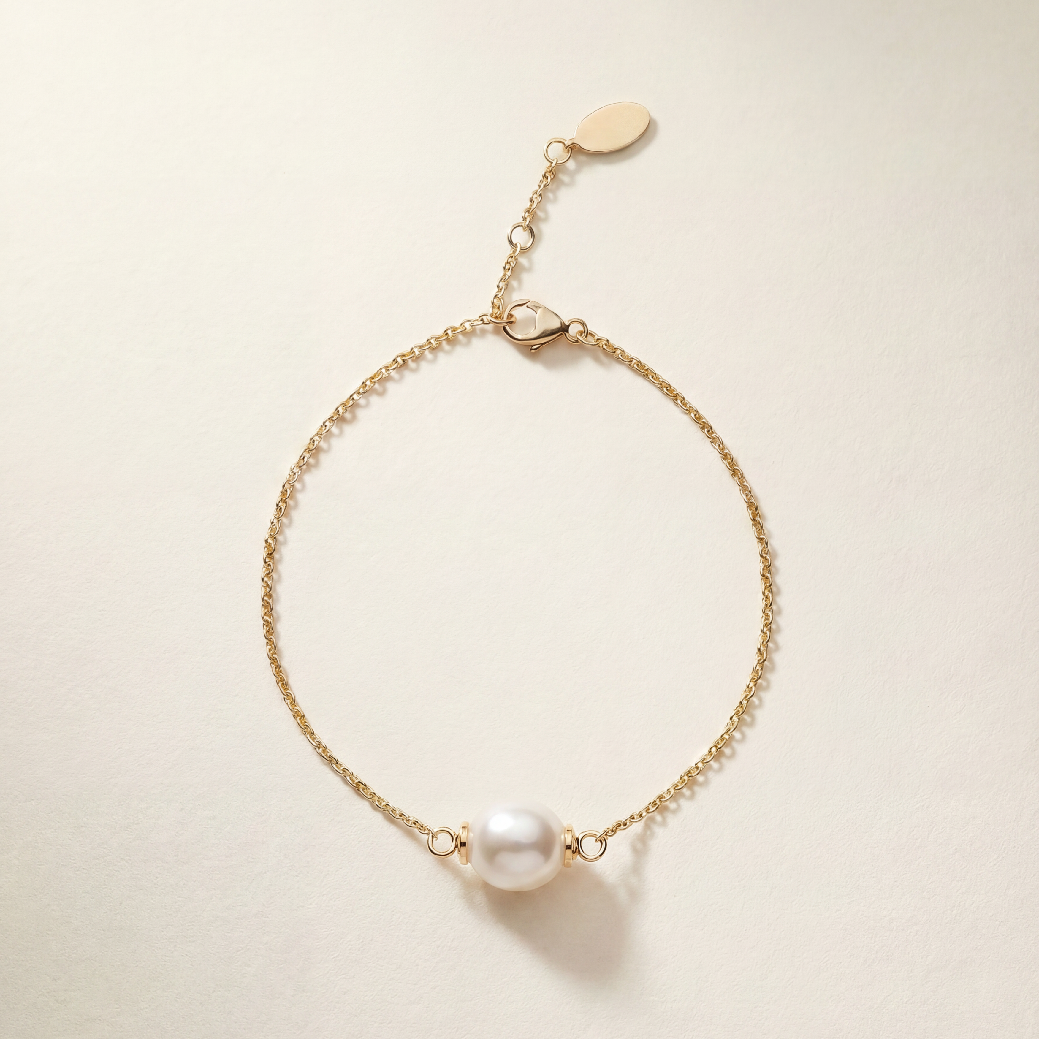 Gold bracelet with a pearl on a beige background