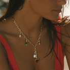 Close-up of 9k solid gold Italian chain necklace with various gemstones and pearl charms.
