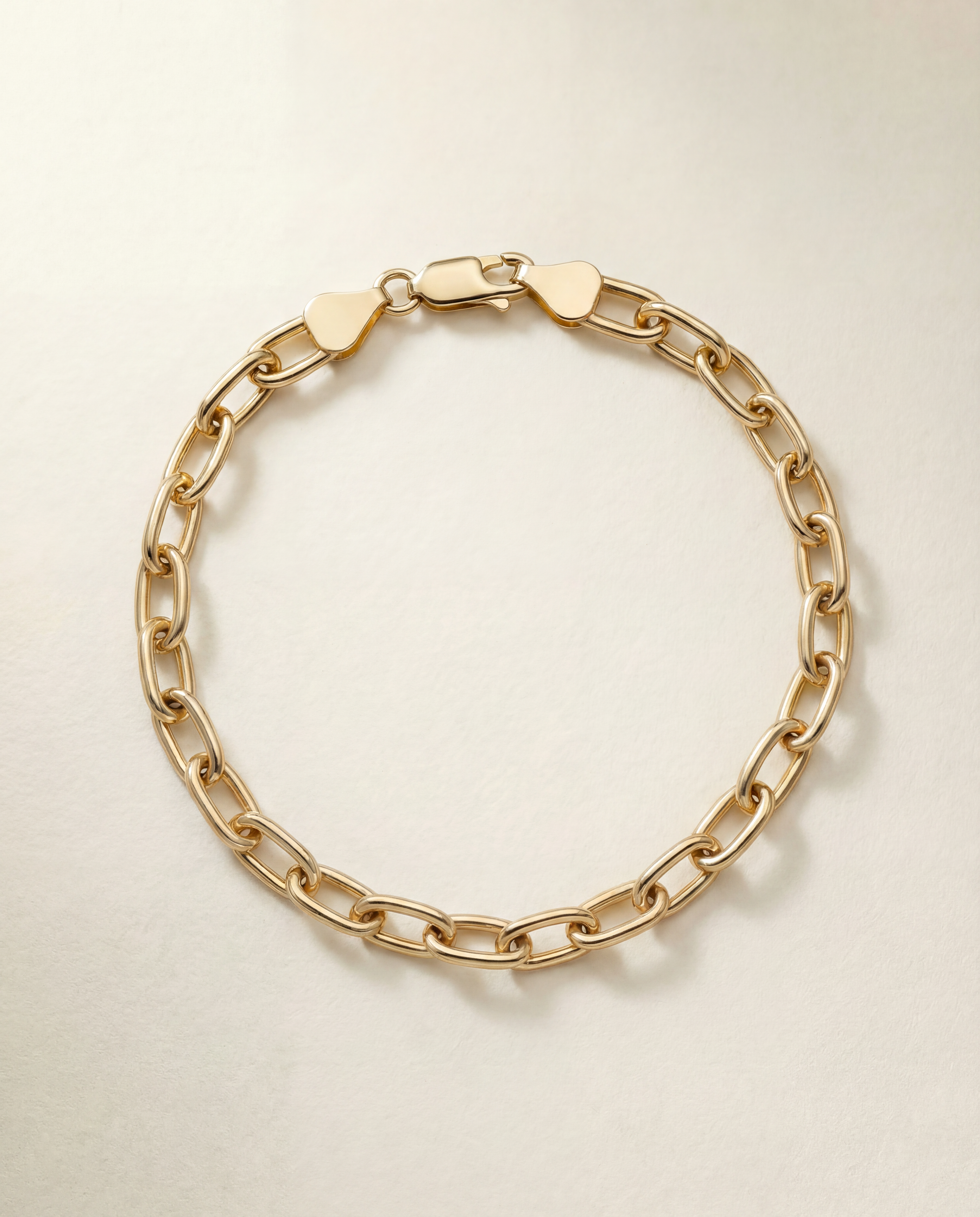 Gold chain bracelet on a light beige background