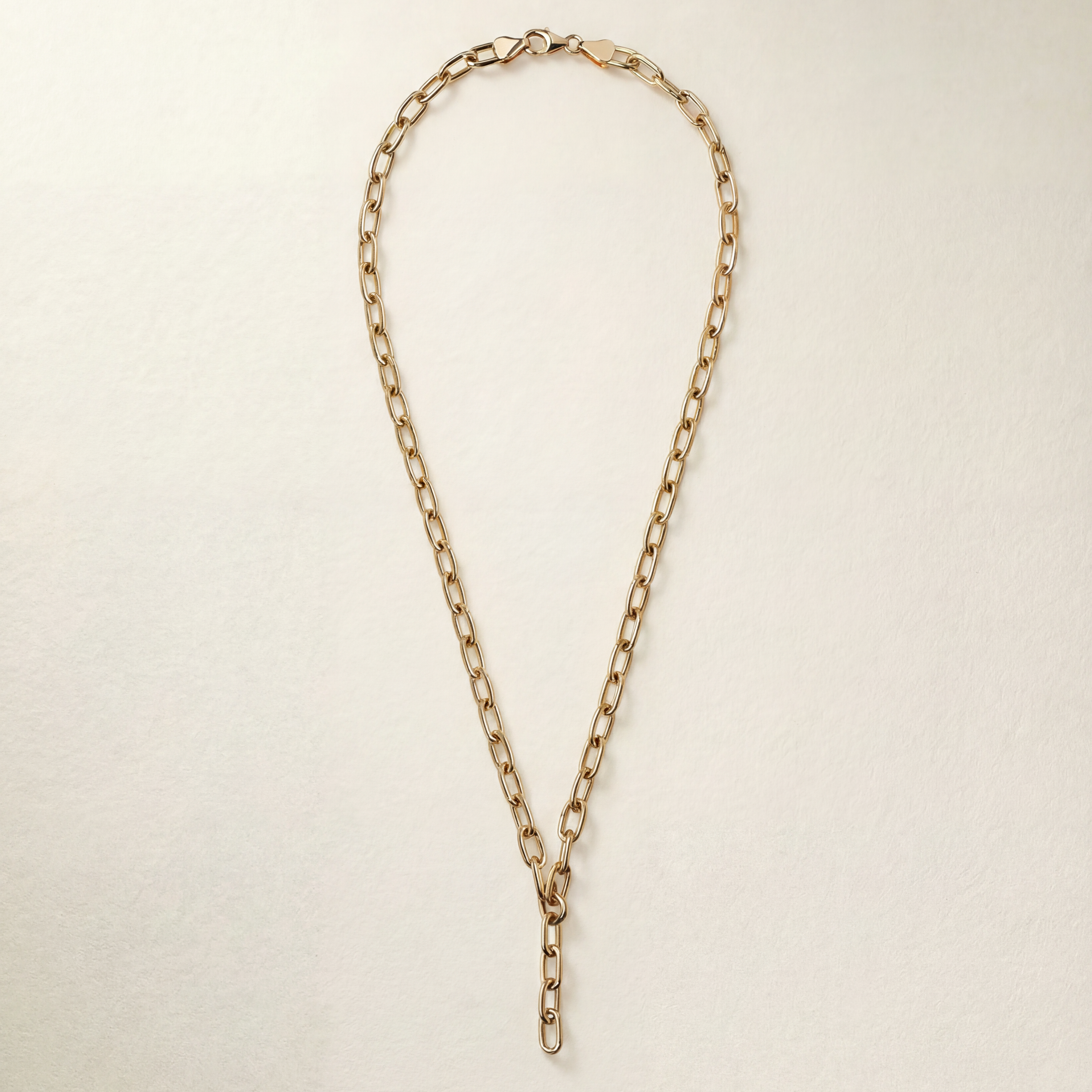 Gold chain necklace on a light beige background