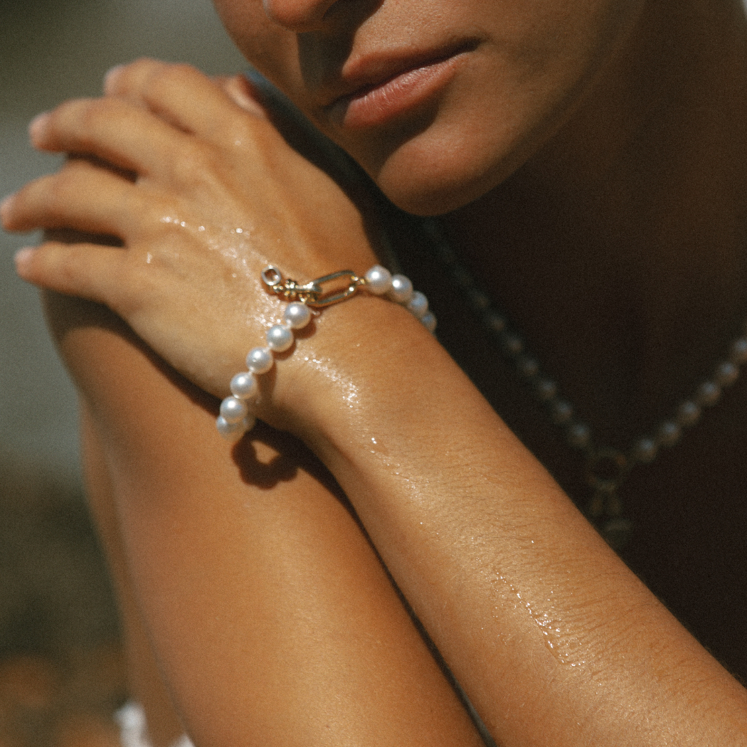 Close-up of South Sea Pearl bracelet with 9kt gold hinged clasp with diamond charm.
