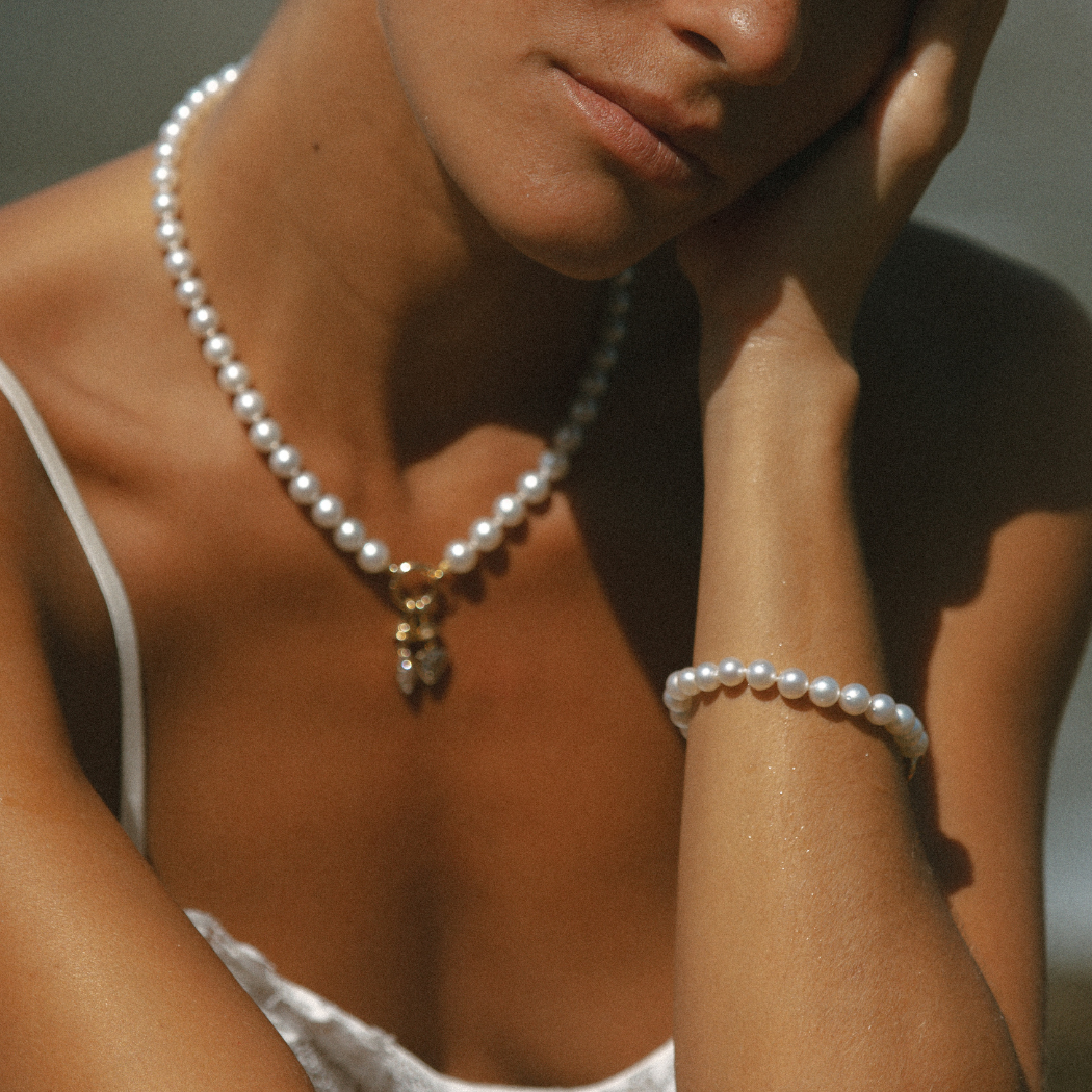 Close-up of South Sea Pearl bracelet and South Sea pearl Necklace with 9kt gold hinged clasp with charms.