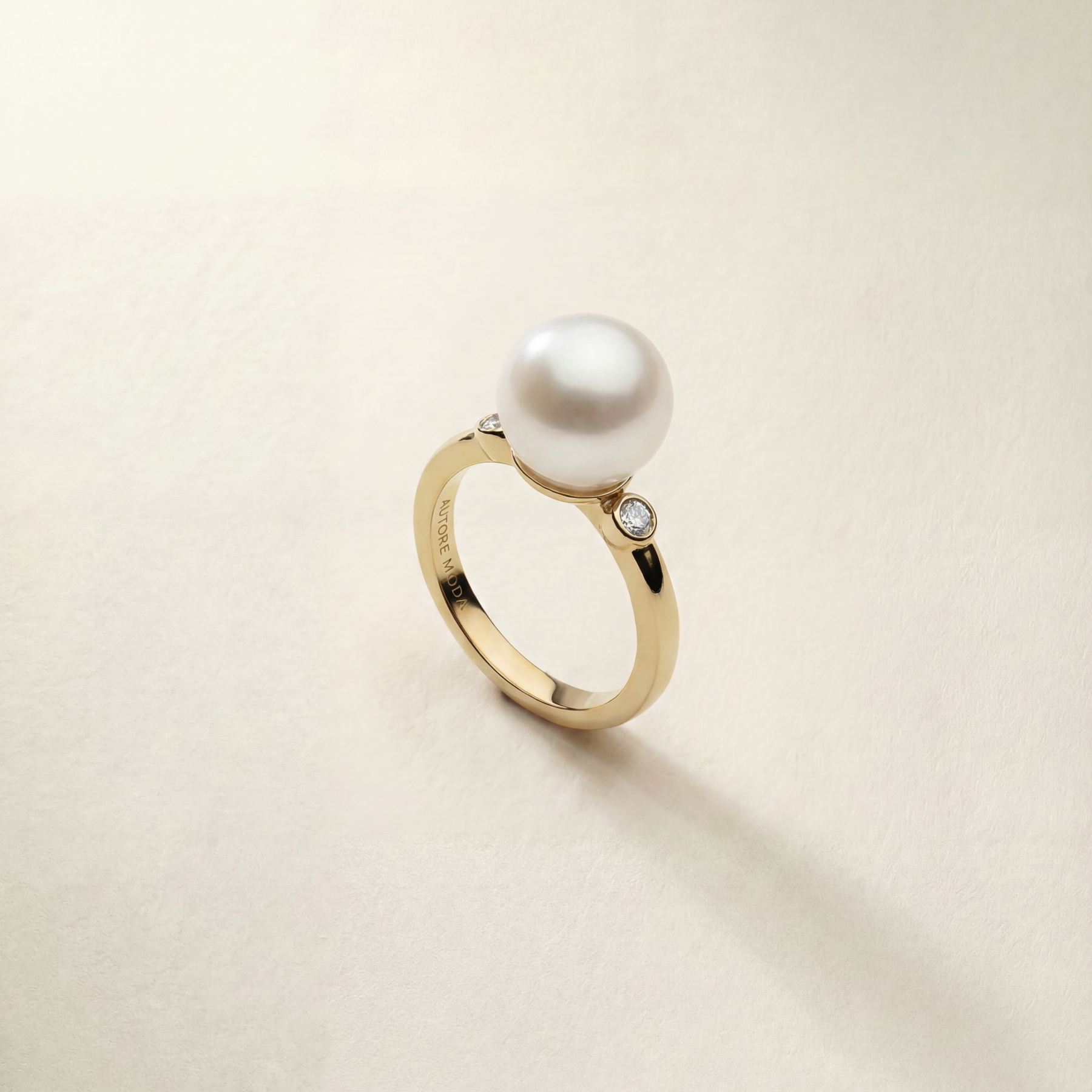 Gold ring with a pearl on a light beige background
