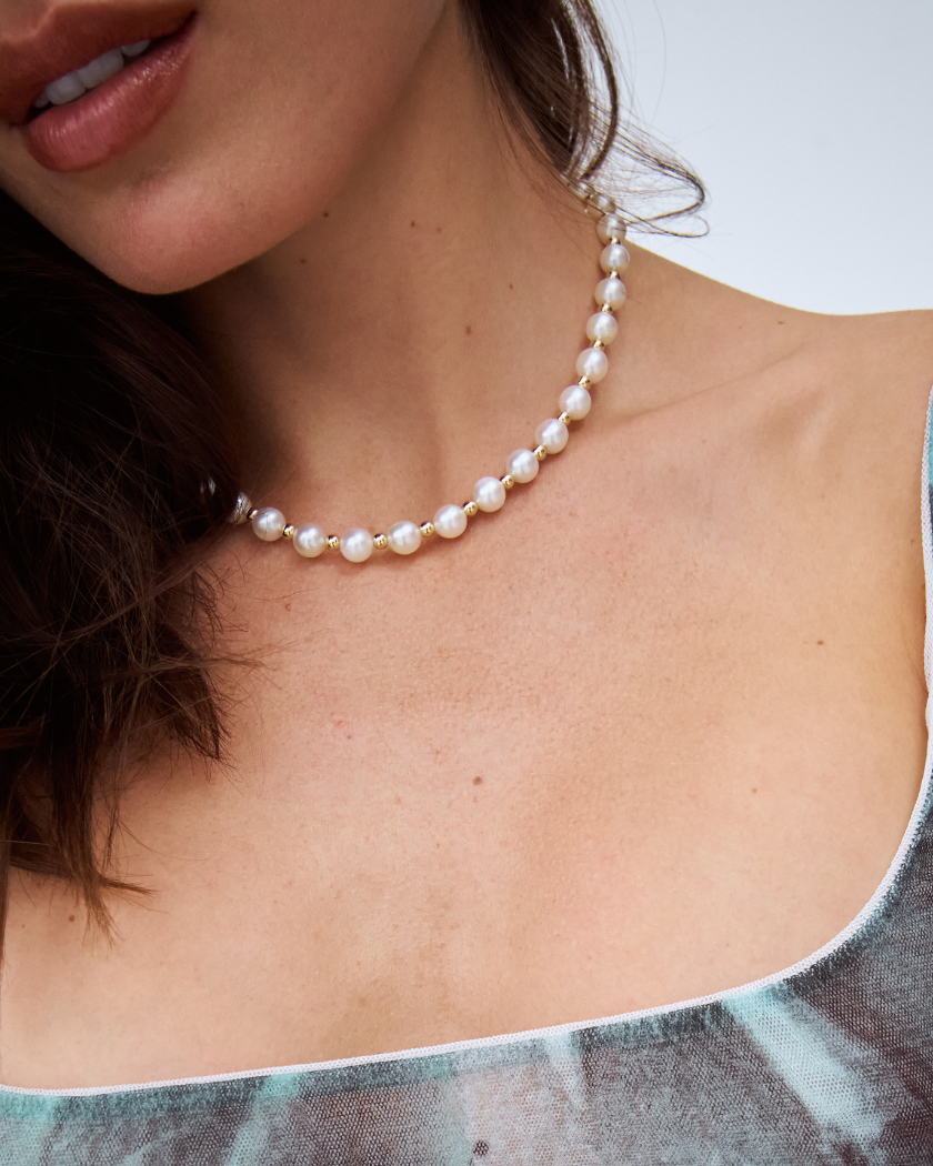 charlotte south sea pearl necklace with gold filled beads and a 9k yellow gold clasp shown on a model