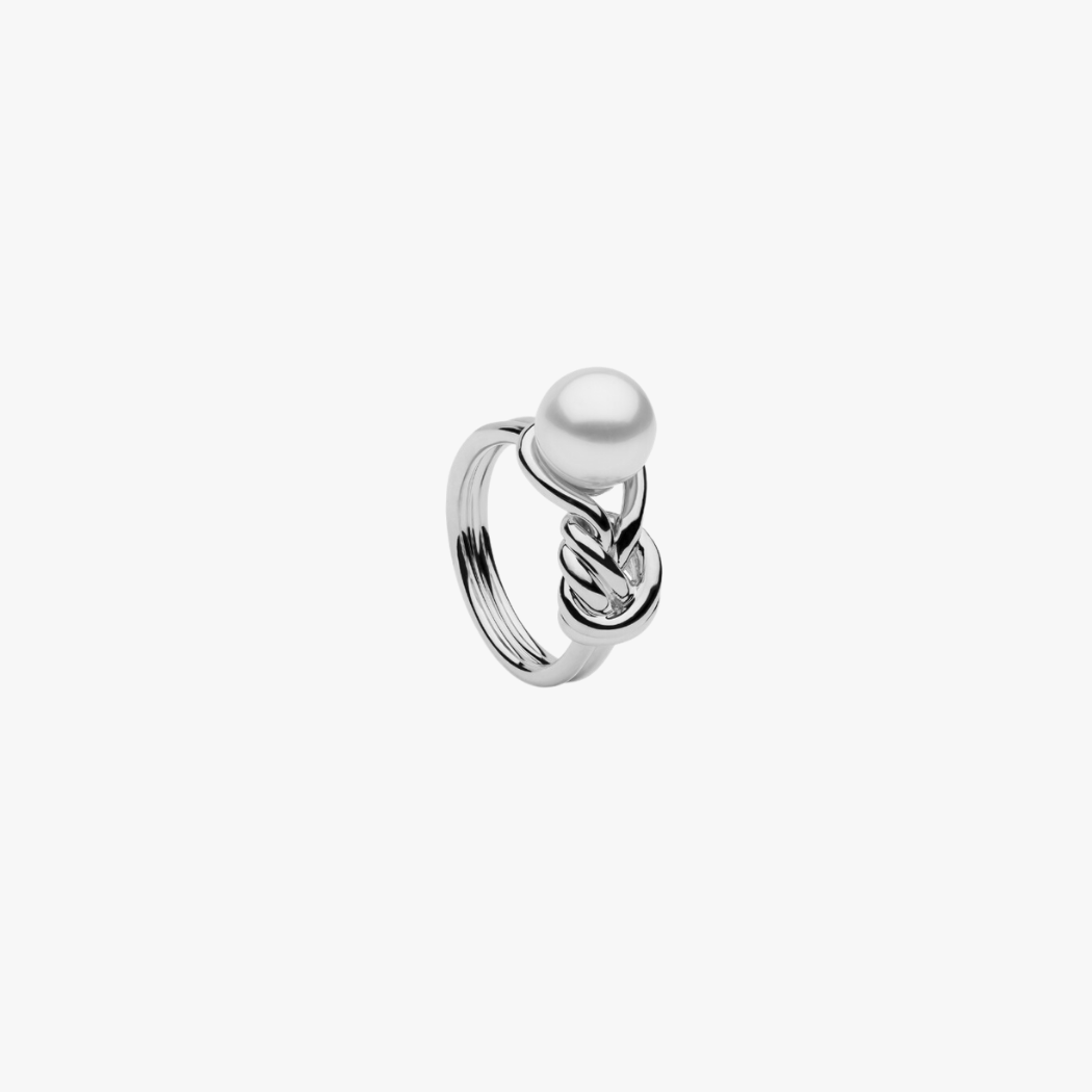 A gold ring featuring a single South Sea pearl with a unique knot design, placed on a white background.