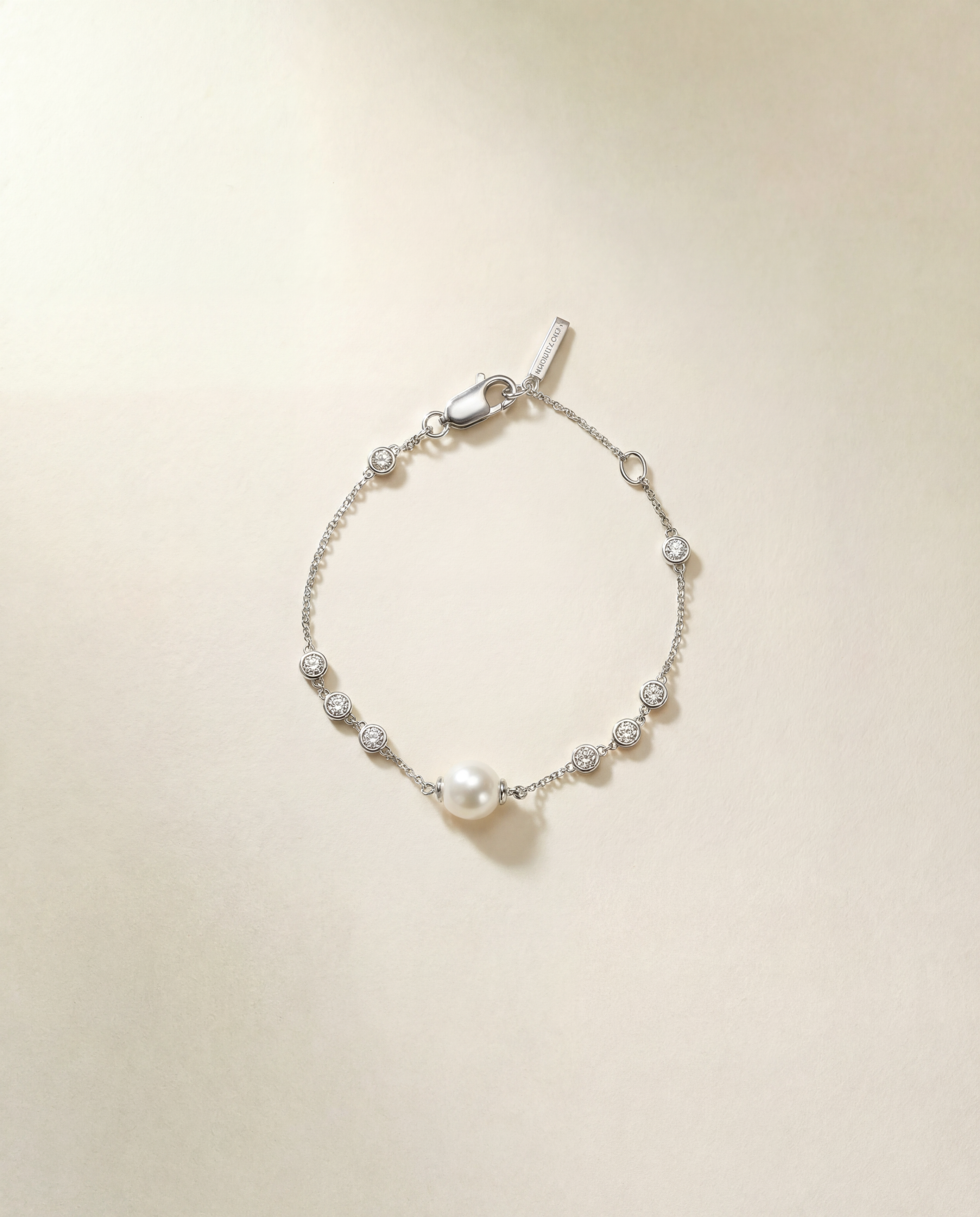 Silver bracelet with pearls on a beige background