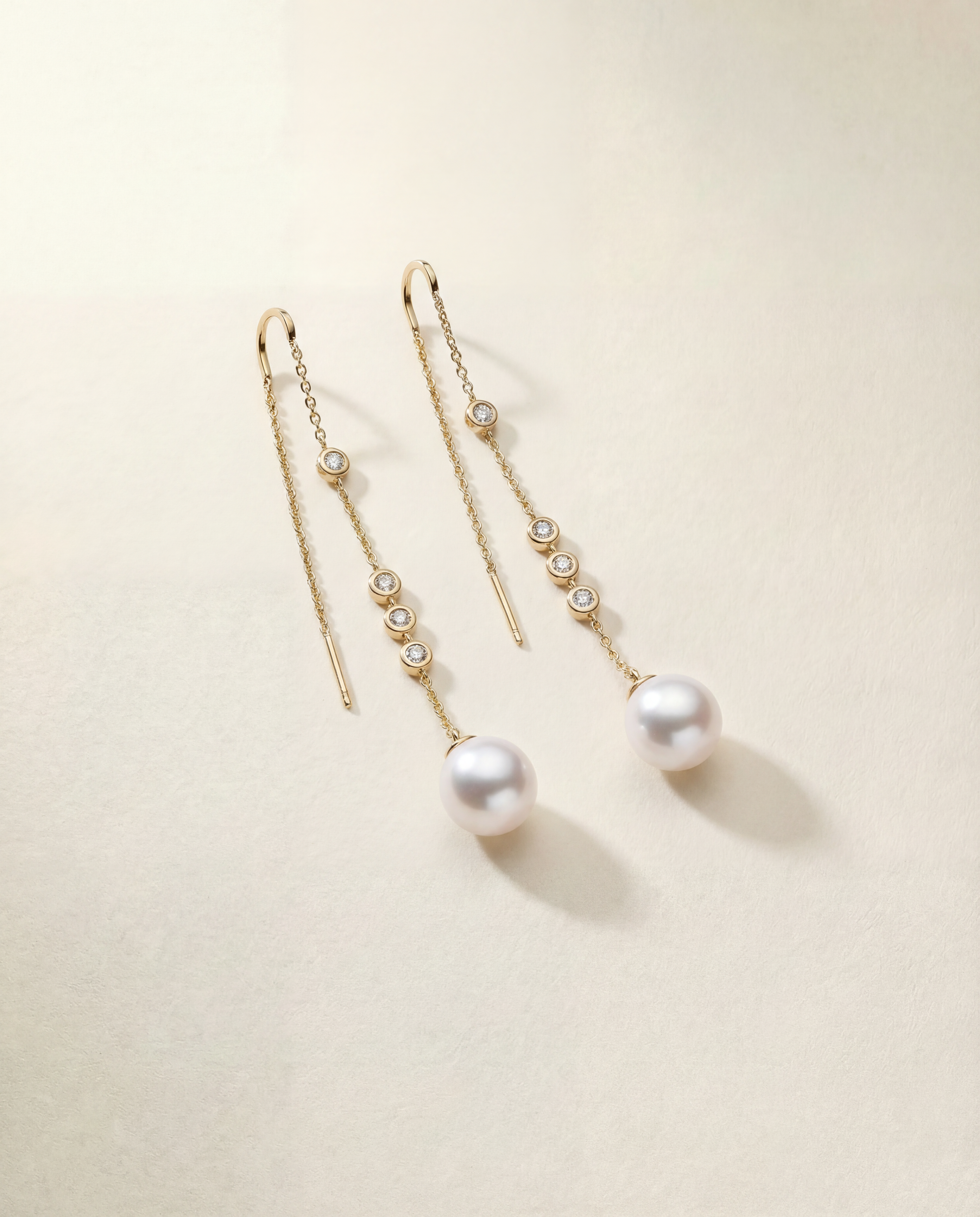 Pair of pearl earrings with diamonds on a light background