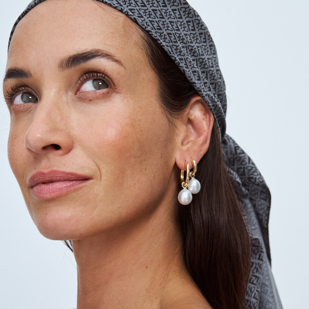 Woman wearing south sea pearl earrings with a neutral background