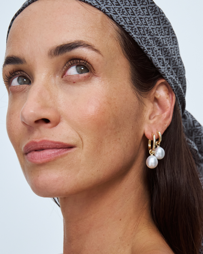 Woman wearing south sea pearl earrings with a neutral background