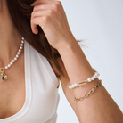 model wearing a round south sea pearl bracelet with a 9k yellow gold rectangle clasp. stacked with a paperclip chain bracelet.