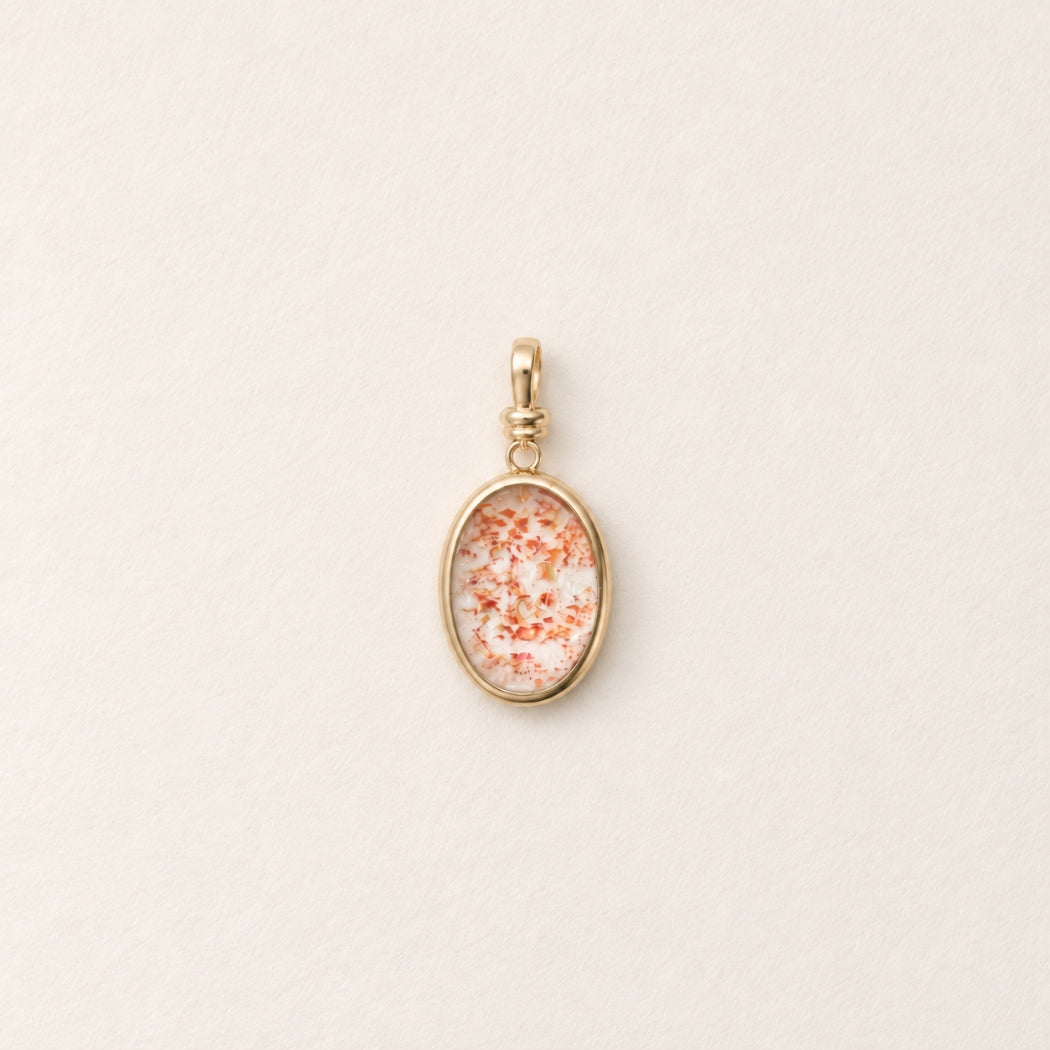 strawberry quartz charm in 9k yellow gold on beige background