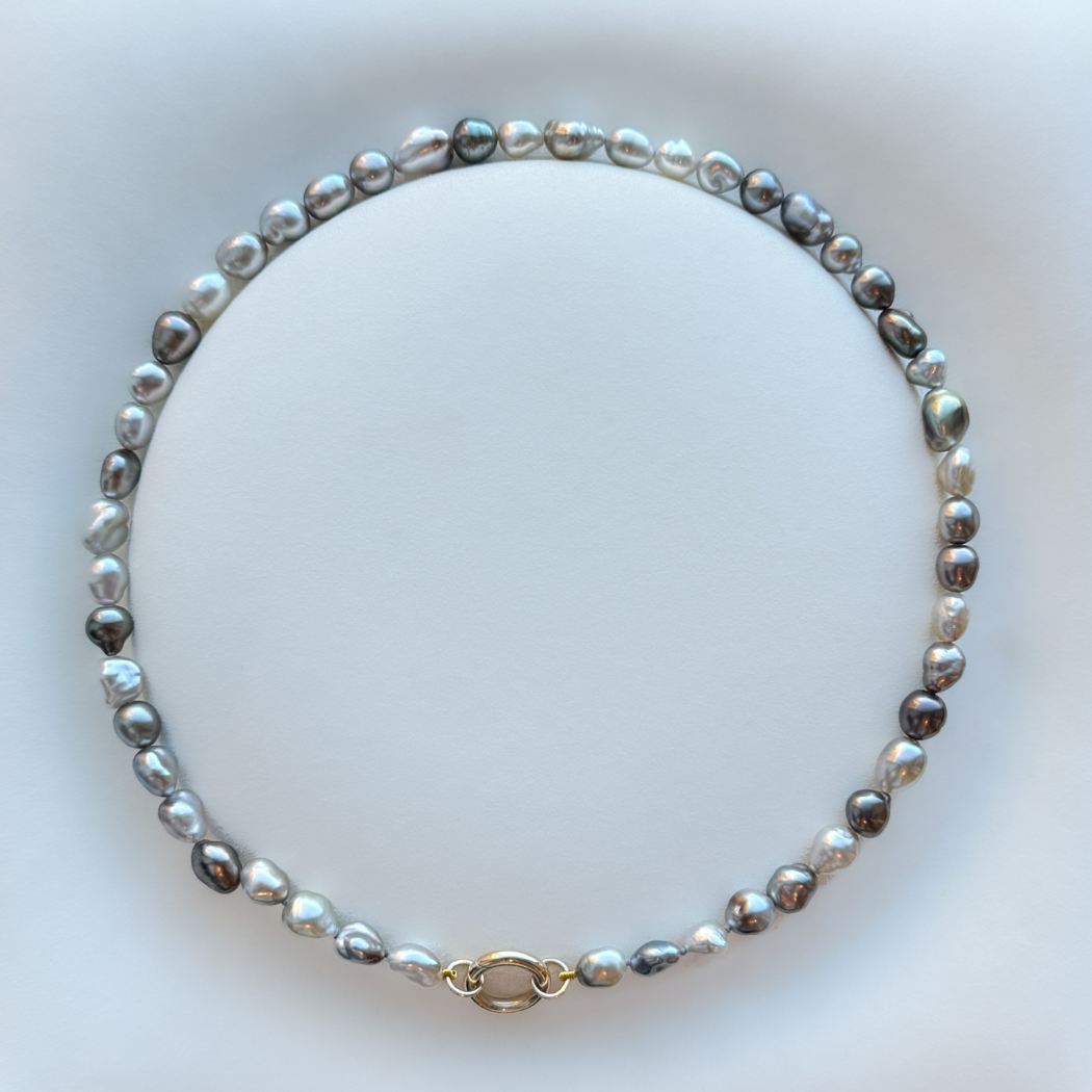 Tahitian keshi pearl necklace with a 9ct yellow gold circular clasp on a white background.